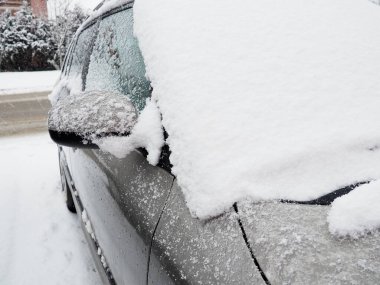 Ön camda kar ve buz, arabanın retrovizörleri ve dikiz aynaları. Kış sürüş koşulları. Kar temizliği. Kışın yol trafiği. Metalik araba. Kar yağışı ve çamur