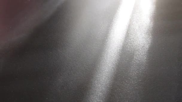 Svítící paprsky na šedém povrchu. Abstraktní paprsky světla a čočky září na šedém pozadí. světlé pruhy. božská záře — Stock video
