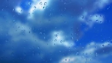 Bardaktan aşağı yağmur damlaları akıyor. Fırtınanın hızı azalıyor. Yumuşak odaklanma. Mavi gökyüzüne karşı hızlı hareket eden bulutlar. Bulutlu kümülüs bulutları rüzgarda gittikçe daha alçaktan ve daha hızlı hareket eder. Meteoroloji ve hava tahmini