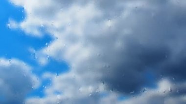 Bardaktan aşağı yağmur damlaları akıyor. Fırtınanın hızı azalıyor. Yumuşak odaklanma. Mavi gökyüzüne karşı hızlı hareket eden bulutlar. Bulutlu kümülüs bulutları rüzgarda gittikçe daha alçaktan ve daha hızlı hareket eder. Meteoroloji ve hava tahmini