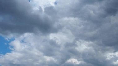 Mavi gökyüzüne karşı hızlı hareket eden bulutlar. Bulutlu kümülüs bulutları rüzgarda gittikçe daha alçaktan ve daha hızlı hareket eder. Meteoroloji ve hava tahmini. Ekolojik sorunlar. İklim değişikliği. Fırtına rüzgarı zaman ayarlı