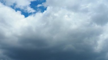 Mavi gökyüzüne karşı hızlı hareket eden bulutlar. Bulutlu kümülüs bulutları rüzgarda gittikçe daha alçaktan ve daha hızlı hareket eder. Meteoroloji ve hava tahmini. Ekolojik sorunlar. İklim değişikliği. Fırtınanın hızı 4K