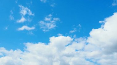 Mavi gökyüzüne karşı hızlı hareket eden bulutlar. Bulutlu kümülüs bulutları rüzgarda gittikçe daha alçaktan ve daha hızlı hareket eder. Meteoroloji ve hava tahmini. Ekolojik sorunlar. İklim değişikliği Fırtınanın hızı 4K