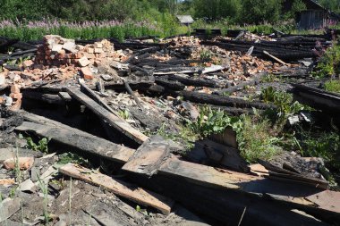 Evin yanmasından sonra, yanmış tahtalar ve tuğlalar kaldı. Trajedi sahnesi. Yangın güvenliği ve acil durumlar. Bir apartmanda çıkan yangının sonuçları. Küller ve yıkıntılar,.