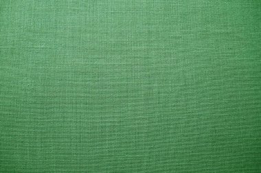 yeşil arka plan kumaş dokusu. Yünlü bir kumaş parçası düzgünce yüzeye serilmiş. Dokuma ve tekstil dokusu. Kumaş ya da mutfak ihtiyaçları için, masa örtüsü ya da perdeler, yakın çekim. Çizgi.