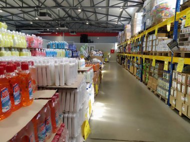 indirimli mağaza zinciri Mthe Ruma, Sırbistan, 15 Nisan 2022. Depoda düşük fiyattan yiyecek ve ev eşyaları satılıyor. Yiyecek ve içecek raflarda. Paletlerin üzerindeki kutular. Sarı fiyat etiketleri.