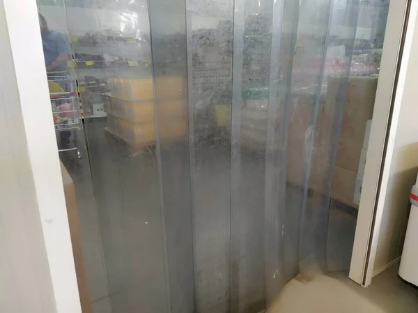 Curtains made of polyurethane film or PVC. Entrance to the cold room of the store with meat and dairy products. Transparent film for imitation of a door, temperature retention and noise insulation