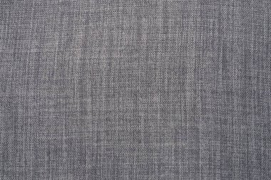 Gri arka plan kumaş dokusu. Yünlü bir kumaş parçası düzgünce yüzeye serilmiş. Dokuma ve tekstil dokusu. Kumaş ya da mutfak ihtiyaçları için, masa örtüsü ya da perdeler, yakın çekim. Çizgi.