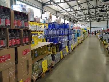 indirimli mağaza zinciri Mthe Ruma, Sırbistan, 15 Nisan 2022. Depoda düşük fiyattan yiyecek ve ev eşyaları satılıyor. Yiyecek ve içecek raflarda. Paletlerin üzerindeki kutular. Sarı fiyat etiketleri.