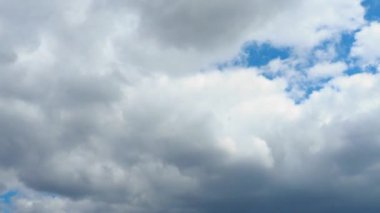 Mavi gökyüzüne karşı hızlı hareket eden bulutlar. Bulutlu kümülüs bulutları rüzgarda gittikçe daha alçaktan ve daha hızlı hareket eder. Meteoroloji ve hava tahmini. Ekolojik sorunlar. İklim değişikliği. Fırtınanın hızı 4K