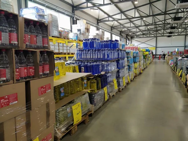 indirimli mağaza zinciri Mthe Ruma, Sırbistan, 15 Nisan 2022. Depoda düşük fiyattan yiyecek ve ev eşyaları satılıyor. Yiyecek ve içecek raflarda. Paletlerin üzerindeki kutular. Sarı fiyat etiketleri.