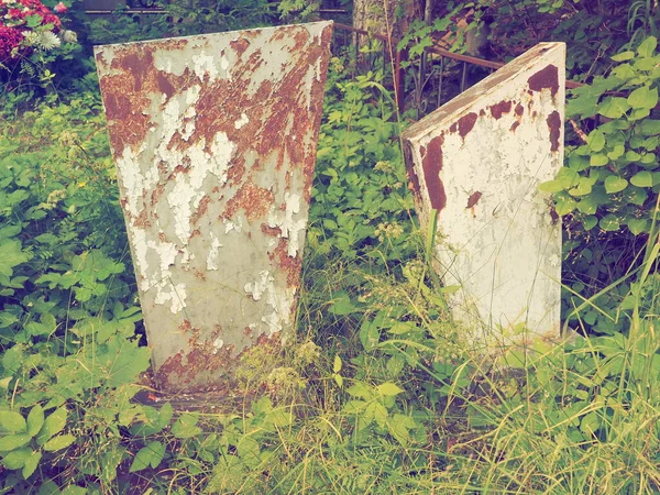 Cemetery with stone monuments. Old abandoned cemetery in the afternoon in summer. Grass thickets. Old granite monuments on the graves. Human graves. The theme of oblivion, calm, death and Halloween.