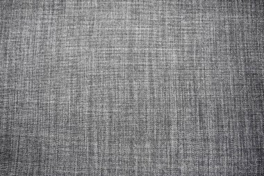 Gri arka plan kumaş dokusu. Yünlü bir kumaş parçası düzgünce yüzeye serilmiş. Dokuma ve tekstil dokusu. Kumaş ya da mutfak ihtiyaçları için, masa örtüsü ya da perdeler, yakın çekim. Çizgi.