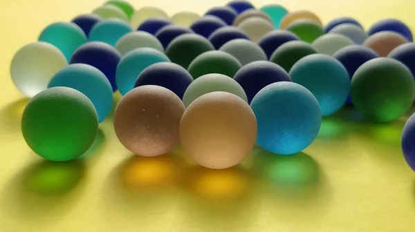 Bolas Geadas Vidro Azul Verde Uma Superfície Amarela Parcialmente Desfocada — Fotografia de Stock