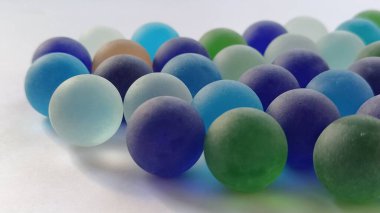 Oyun kumandaları ya da beyaz arka plana saçılmış renkli cam toplar. arka ışıklandırma.