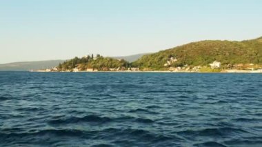 Boka Kotor Adriatic Sea, Verige Strait Kamenari Lepetane Ferry Line Trajekt. Ferryboat for passenger, cargo and vehicles. Water and waves. Seashore with houses, road and cars August 16 2022.