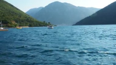 Boka Kotor Adriatic Sea Verige Strait Kamenari Lepetane Ferry Line Trajekt. The boat rushes along the blue waves. Two mountains. Tourism and business in Montenegro. Maritime transport. August 18 2022