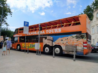Dubrovnik, Hırvatistan, 18 Ağustos 2022. Otobüs durağında turuncu çift katlı turist otobüsü. Kadının ve kızın acelesi var. Yol ve araçlar şehir merkezinde. Adriyatik Turizmi