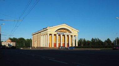 Karelia Cumhuriyeti Müzikal Tiyatrosu, Petrozavodsk 'ta yer alan bir devlet tiyatrosudur. İnsanlar yürüyor. Arabalar Kirov Meydanı boyunca gider. Karl Marx Caddesi 'nden bir araba geçiyor. Mavi gökyüzü. 3 Ağustos 2022.