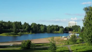 Mouth, taşkın ovası ve Lososinka Nehri 'nin terasları, Petrozavodsk, Karelia Cumhuriyeti 3 Ağustos 2022. Güneşli, rüzgarsız bir akşam. Şehir kumsalı. Yoldan geçen ve çocuklu insanlar yürür. Otel Karelia.