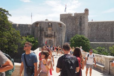 Pile Gate Dubrovnik Hırvatistan 14 Ağustos 2022 Erkekler ve kadınlar taş köprü boyunca Eski Şehir 'in kapısına yürüyorlar. Turist kalabalığı. Yoğun giriş. Eski şehrin ana girişi, işlek Yığın Kapısı