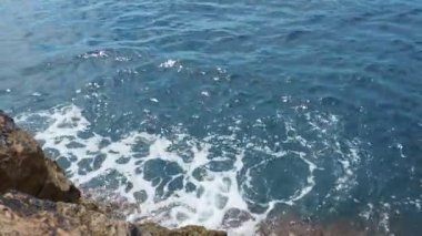 Hırvatistan 'ın Dubrovnik kentinde kayalara ve kayalıklara vuran deniz dalgaları. Buza plajı. Kayalık sahil ve dalgalar. Beyaz şapkalı mavi su. Yumuşak güneş ışığı. Doğa, ekoloji, bilim, seyahat, turizm teması
