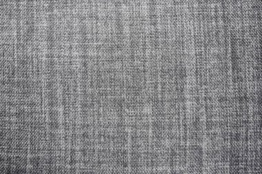 Gri arka plan kumaş dokusu. Yünlü bir kumaş parçası düzgünce yüzeye serilmiş. Dokuma ve tekstil dokusu. Kumaş ya da mutfak ihtiyaçları için, masa örtüsü ya da perdeler, yakın çekim. Çizgi.