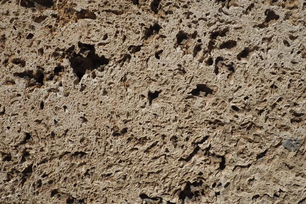 ベージュのシェルロックタイルで裏打ちされたテクスチャ壁 古代のシェルロックで作られた壁のクローズアップ 天然建築材料の凹凸 セルビアのバンジャ コビジャカに教会の壁 — ストック写真