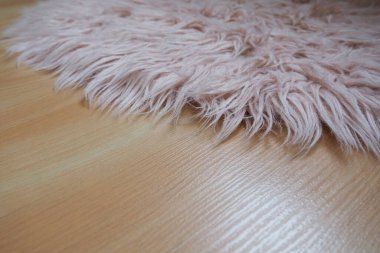 Bej kaplamalı yerde pembe halı var. Bir kız ya da kadının yatak odası ya da odası için kadınsı bir iç mekan. Pembe tonlarda iç dizayn. Döşeme lamine. Alerjide toz akarlarının rolü