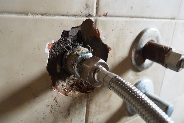 ボイラーから出る温水パイプの交換 新しいホースだ 壁に瓦が割れた 浴室又は台所の壁の開口部と水漏れ 事故及び配管工事 — ストック写真