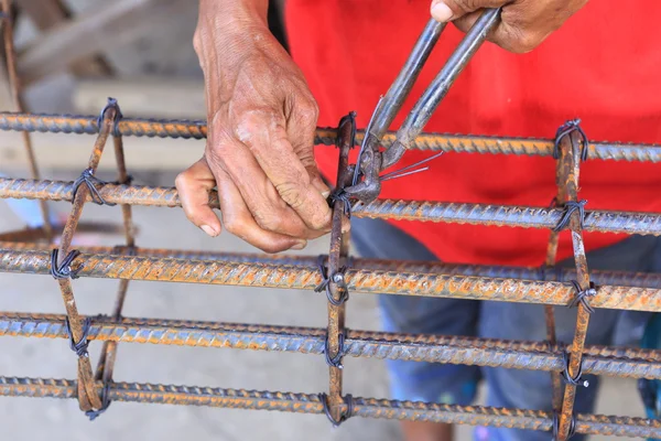 Arbejdstager bøjning stål til byggeri job - Stock-foto