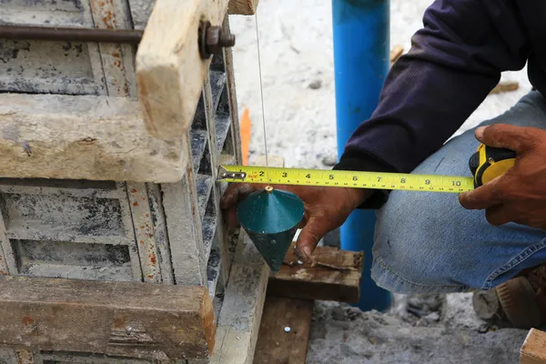 Labor man using a plumb bob for check — Stock Photo, Image