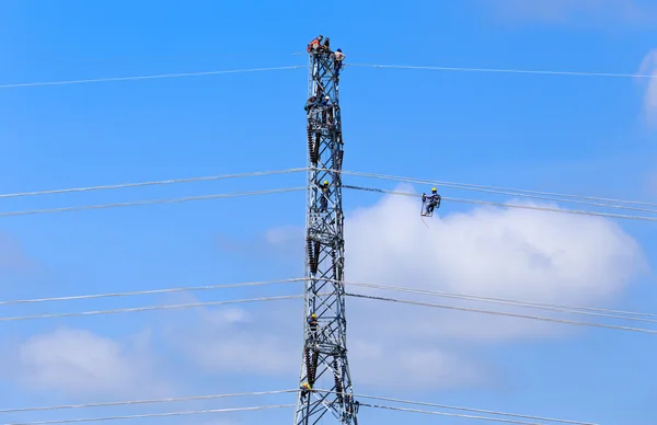 Trabalhador eletricista no trabalho de escalada em poste de alta tensão — Fotografia de Stock