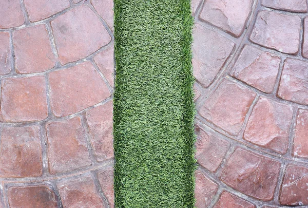 Erba artificiale sul pavimento di ston — Foto Stock