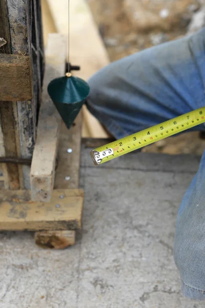 Labor man using a plumb bob for check — Stock Photo, Image