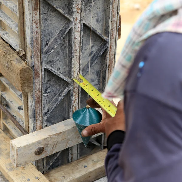 Labor man using a plumb bob for check — Stock Photo, Image