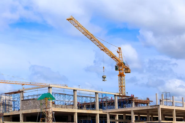 Guindaste trabalhando na construção no céu azul — Fotografia de Stock