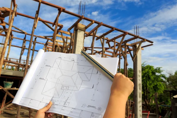 Architecture drawings in hand on house building background — Stock Photo, Image