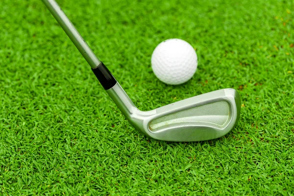 Pelota de golf en tee delante del conductor en el campo verde —  Fotos de Stock