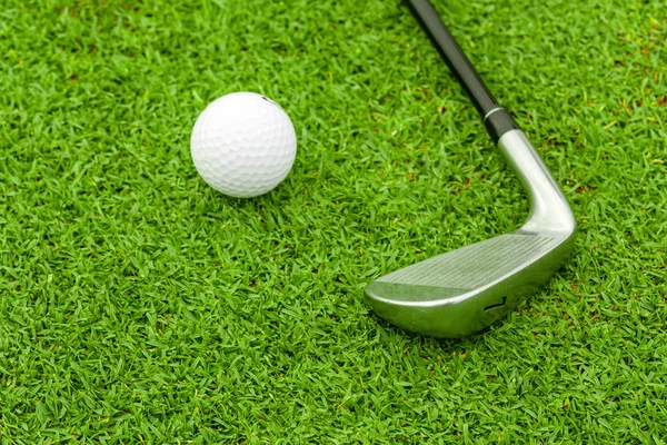 Pelota de golf en tee delante del conductor en el campo verde —  Fotos de Stock