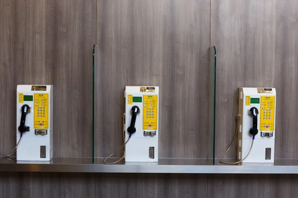 Public telephone coin on wooden wall