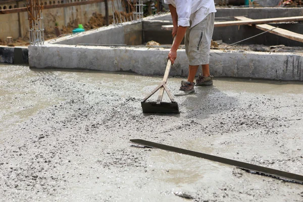 Un operaio in calcestruzzo intonaco al lavoro sul pavimento — Foto Stock