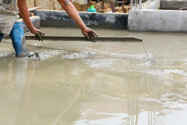 Um trabalhador de concreto de gesso no trabalho no chão — Fotografia de Stock