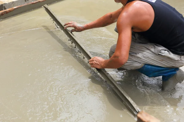 Um trabalhador de concreto de gesso no trabalho no chão — Fotografia de Stock