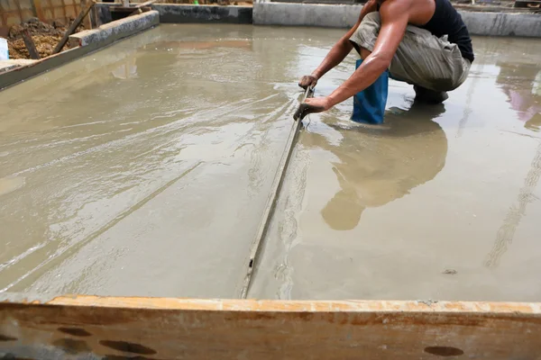 Een werknemer Stukadoor betonnen vloer arbeidsongevallen — Stockfoto