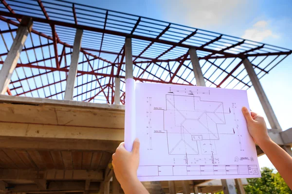 Architecture drawings in hand on house building — Stock Photo, Image