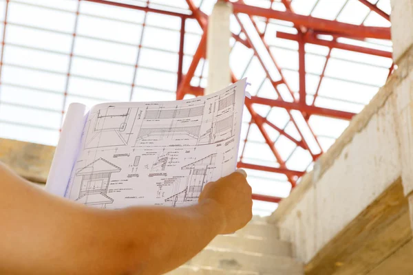 Architecture drawings in hand on house building — Stock Photo, Image