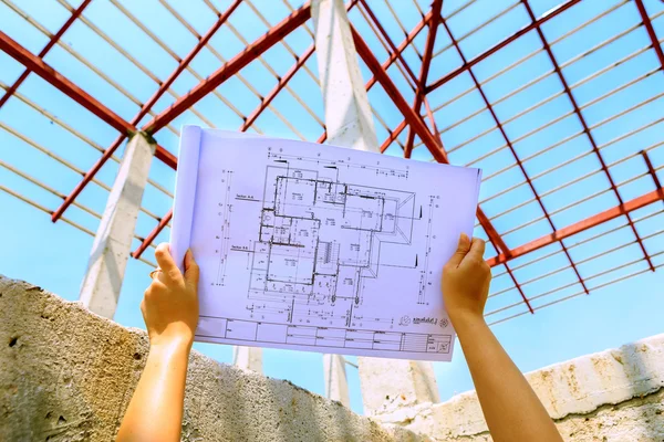 Architecture drawings in hand on house building — Stock Photo, Image