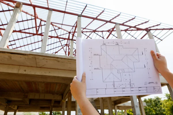 Architecture drawings in hand on house building — Stock Photo, Image