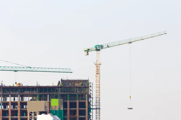 Baustelle mit Kran und Arbeitern am blauen Himmel — Stockfoto